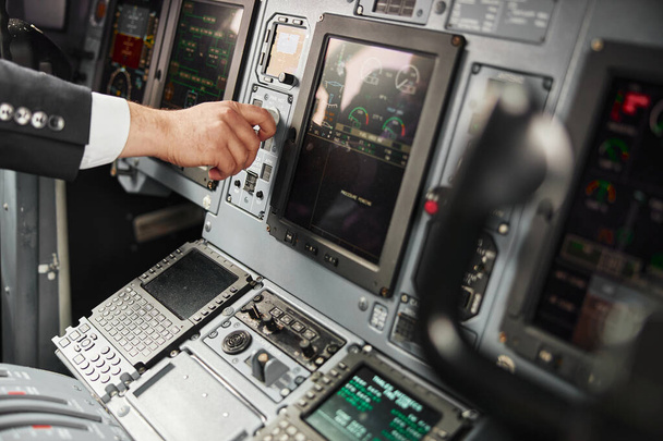Κουμπί στροφής του ανδρικού χειριστή στο επιβατικό αεροπλάνο - Φωτογραφία, εικόνα