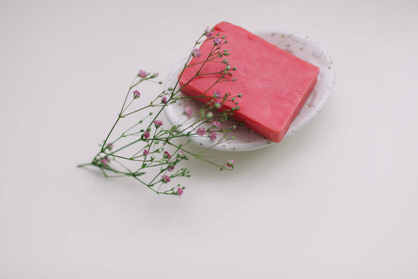 Natural handmade soap bar with ceramic soap dish and flowers, spa organic soap, sustainable lifestyle - Photo, Image