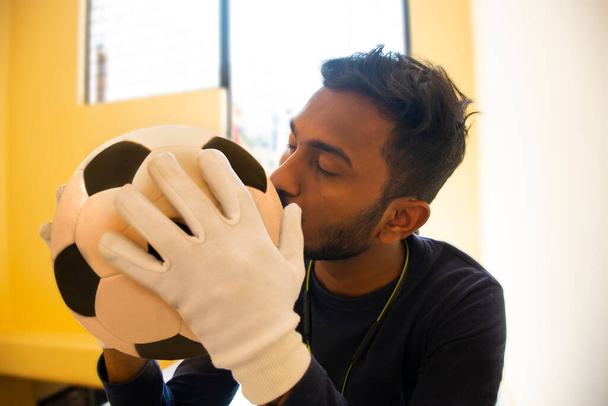Portrait of Indian Footballer kissing soccer ball - Fotó, kép