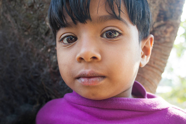 Портрет деревенского ребенка, стоящего на открытом воздухе - Фото, изображение
