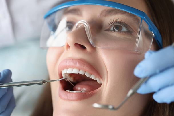 Dentist examines oral cavity of woman patient - Fotoğraf, Görsel