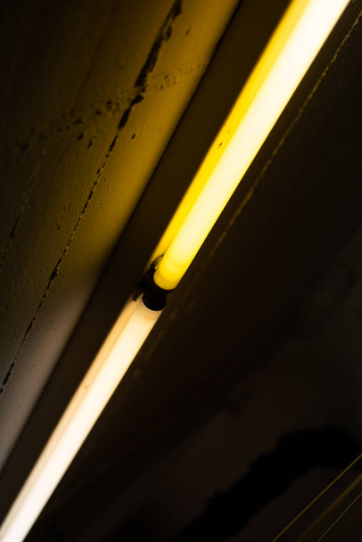 Vieux défectueux scintillement jaune néon lumières plafond monté à l'intérieur chambre sombre aucun détail de personnes plan rapproché. - Photo, image