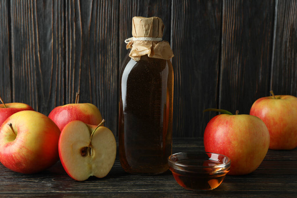 Homemade apple vinegar and ingredients on wooden background - Photo, image