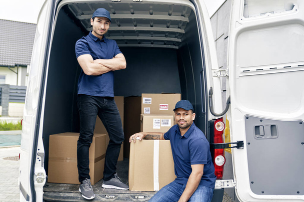 Portrait of couriers in a trunk full of parcels - Photo, Image