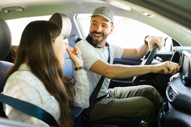 Wonderful idea! Cheerful man and woman looking surprised and happy while talking about a vacation spot while taking a road trip together as a couple - Photo, Image