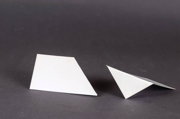 Абстрактный геометрический состав различных белых фигур на сером фоне. Две геометрические формы с только правильными и острыми углами. Селективный фокус. - Фото, изображение