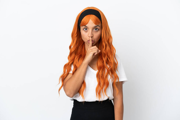 Young woman with orange hair isolated on white background showing a sign of silence gesture putting finger in mouth - Foto, afbeelding