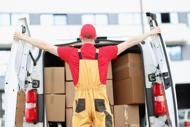 Male courier opening minivan car with many cardboard boxes - Zdjęcie, obraz