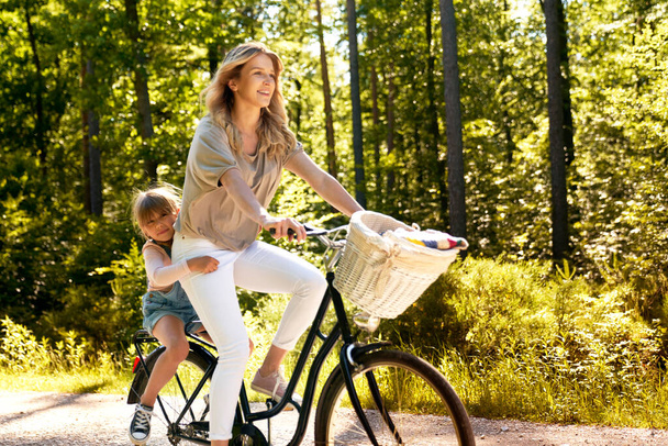 Mère et fille faisant du vélo dans la forêt - Photo, image