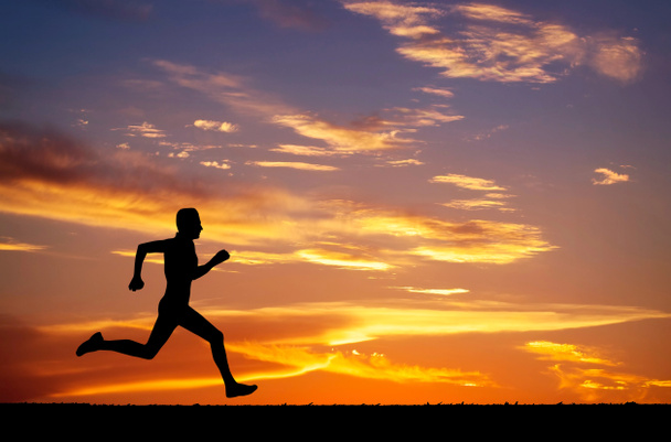Silueta del hombre corriendo sobre fondo ardiente puesta de sol
  - Foto, imagen