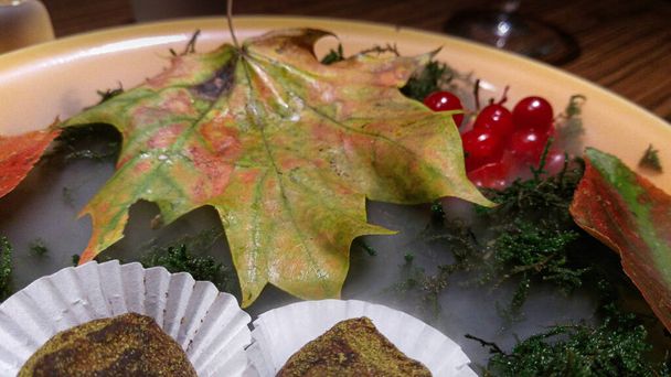 feuille d'érable, potassium, aiguilles et bonbons dans une assiette, haute cuisine - Photo, image