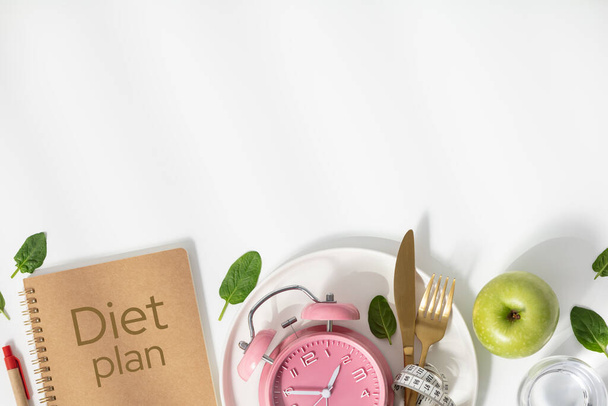 Composition with cutlery, measuring tape, diet plan and alarm clock on color background. Diet concept, copy space - Zdjęcie, obraz