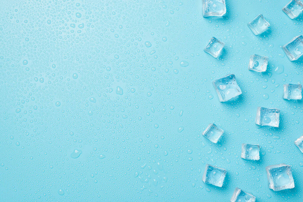 Overhead photo of pile of cubes ice and drops isolated on the blue background with empty space - Foto, Imagen