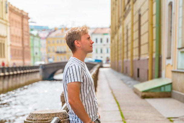 Ein junger Mann läuft an einem Sommertag in St. Petersburg durch die Innenstadt entlang der Kanäle - Foto, Bild