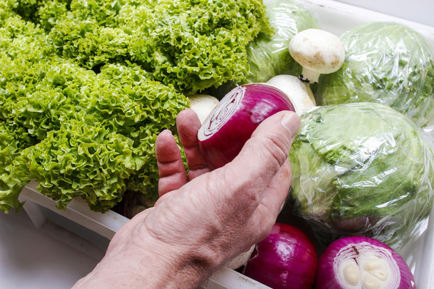 Man choosing onion from box of fresh vegetables - Foto, Bild