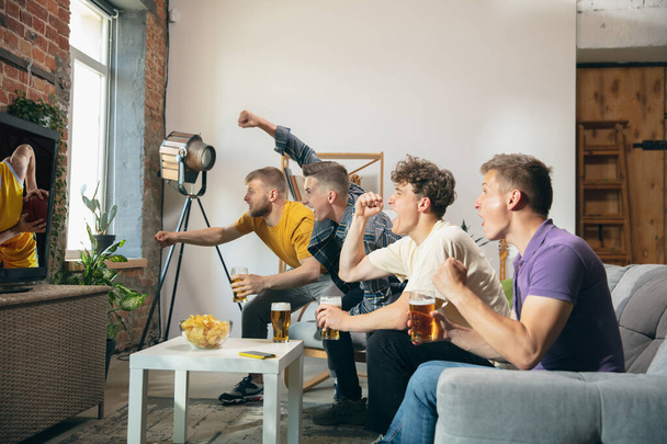Group of friends watching TV, sport match together. Concept of friendship, leisure activity, emotions - Fotoğraf, Görsel
