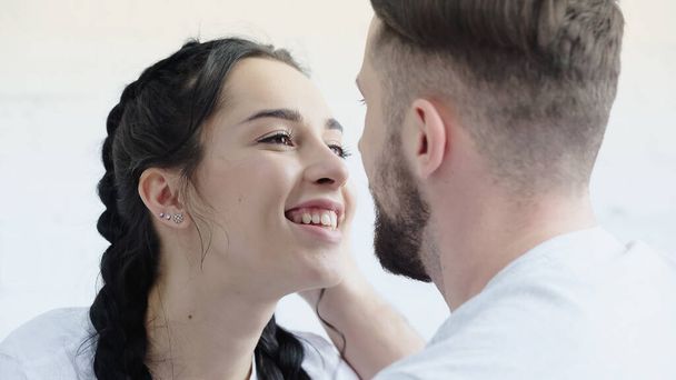 happy woman with braids looking at bearded boyfriend at home - Photo, image
