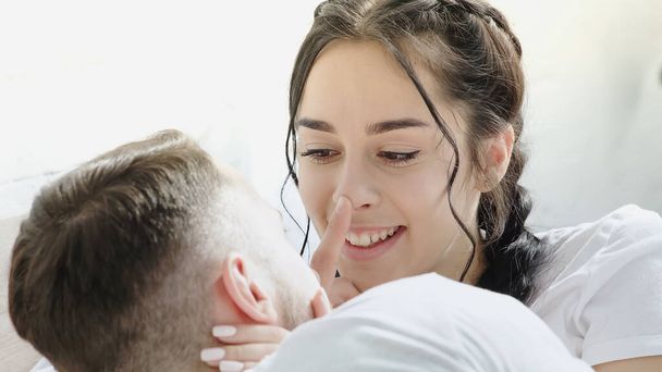 boyfriend touching nose of happy brunette woman with braids  - Фото, изображение