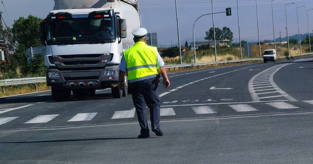 道路上の交通警察官黄色のジャケットターン - 写真・画像