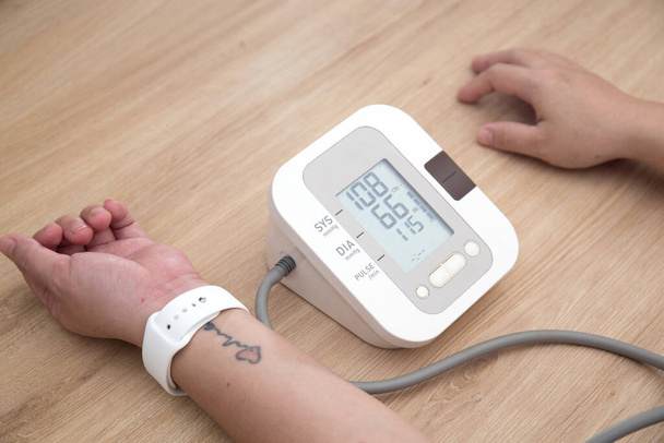 Vrouwelijke bloeddruk en hartslag met digitale manometer standaard bloeddruktestresultaten Gezondheid en Medisch concept - Foto, afbeelding