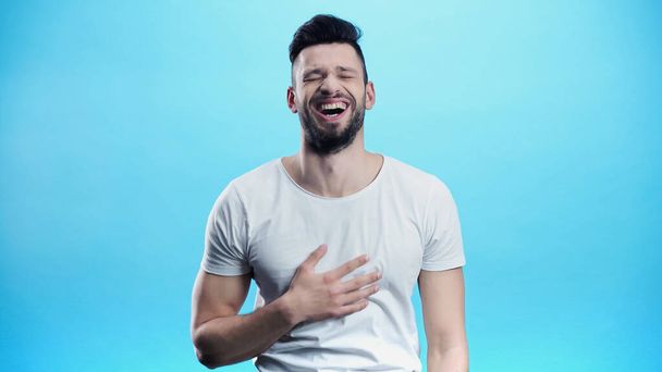 excited man laughing with closed eyes isolated on blue - Fotografie, Obrázek