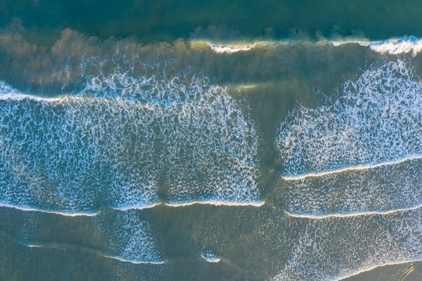 Letecký snímek krásné pláže s výhledem na oceánské vlny a vody zřícení na písečný břeh z horního úhlu - Fotografie, Obrázek
