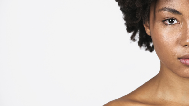 Καλλιεργημένη άποψη της αφρικανικής αμερικανικής γυναίκας με καθαρό δέρμα κοιτάζοντας κάμερα απομονωμένη σε γκρι  - Φωτογραφία, εικόνα