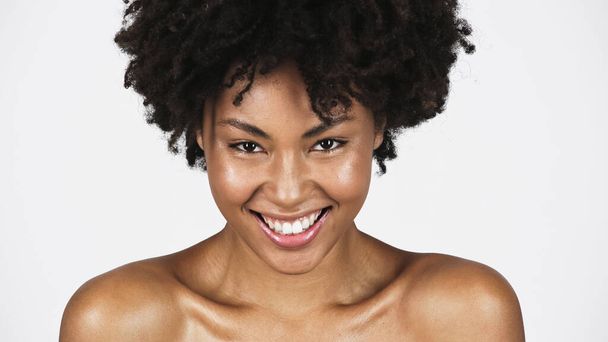 Cheerful african american woman with naked shoulders looking at camera isolated on grey  - Photo, Image
