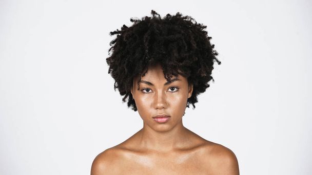 Afro-Amerikaanse vrouw met perfecte huid op zoek naar camera geïsoleerd op grijs  - Foto, afbeelding
