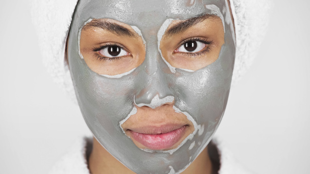 Yüzünde kil maske olan Afrikalı Amerikalı kadının gri renkte izole edilmiş görüntüsü.  - Fotoğraf, Görsel