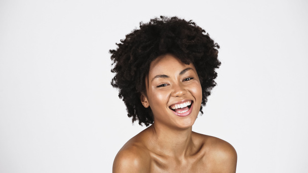 Позитивна афро-американська жінка з чистою шкірою дивиться на камеру ізольовану на сірому  - Фото, зображення