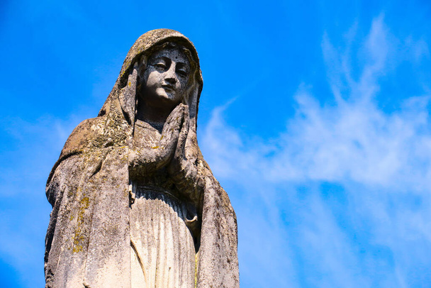 Stenen beeld van de Moeder Gods op het kerkhof - Foto, afbeelding