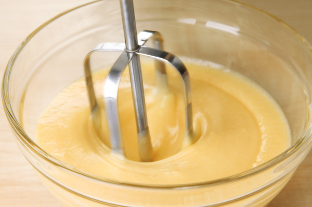 Cooking, whipping eggs with electric whisk in bowl, close up - Foto, afbeelding