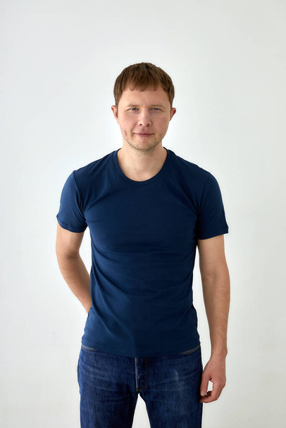 Positive young man in casual outfit standing on white background - Fotografie, Obrázek