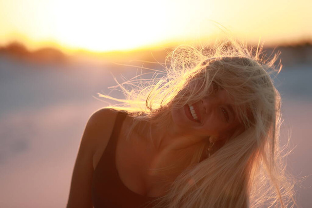 Splendida ragazza abbronzata con una figura su una spiaggia di sabbia in riva al mare  - Foto, immagini