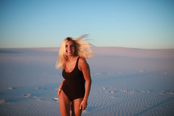 Belle blonde se repose sur la plage de sable près de l'océan - Photo, image