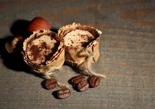 Tasty chocolate candies with coffee beans and nuts on wooden background - Foto, Imagen