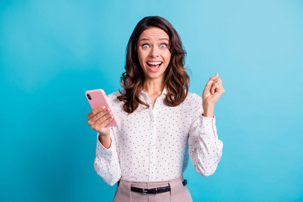 Photo of impressed hooray brunette girl hold telephone wear shirt isolated on teal color background - Fotó, kép
