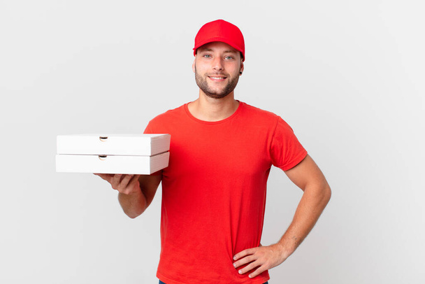 pizza deliver man smiling happily with a hand on hip and confident - Φωτογραφία, εικόνα