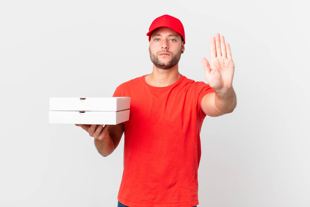 pizza deliver man looking serious showing open palm making stop gesture - Foto, Bild