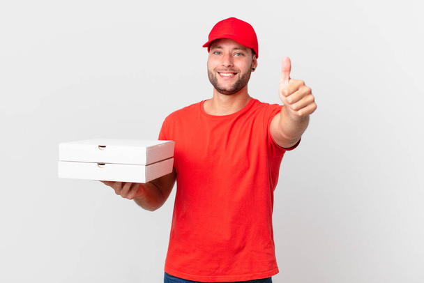 pizza deliver man feeling proud,smiling positively with thumbs up - Foto, immagini