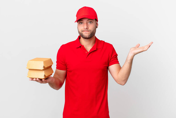 hamburguesa entregar hombre sintiéndose desconcertado y confundido y dudando - Foto, Imagen