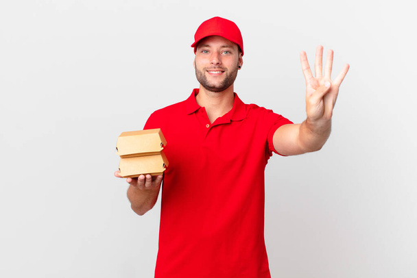 burger deliver man smiling and looking friendly, showing number four - Foto, immagini