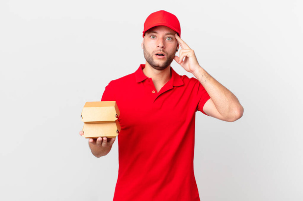 burger deliver man looking surprised, realizing a new thought, idea or concept - 写真・画像