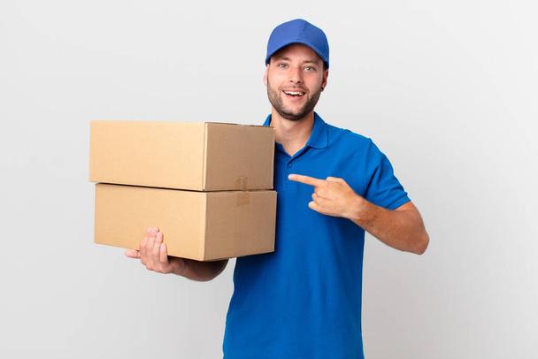 package deliver man looking excited and surprised pointing to the side - Photo, Image
