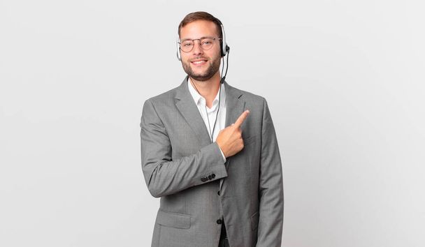 telemarketer businessman smiling cheerfully, feeling happy and pointing to the side - Fotoğraf, Görsel