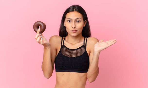 pretty fitness woman with a donut and a breakfast bowl - Foto, Imagen