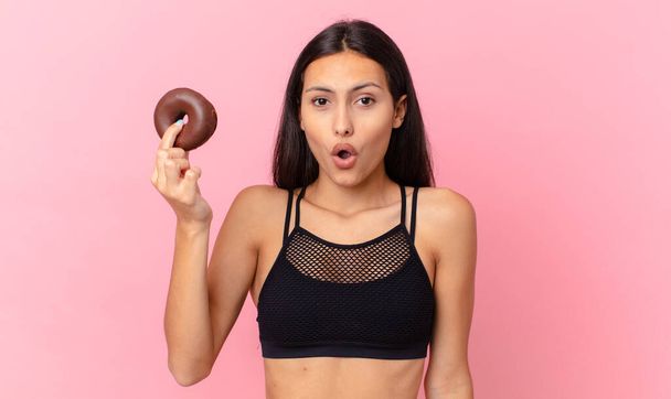 pretty fitness woman with a donut and a breakfast bowl - Foto, imagen