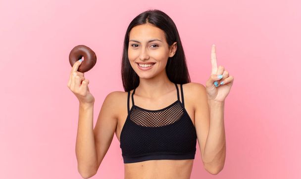 pretty fitness woman with a donut and a breakfast bowl - Foto, afbeelding
