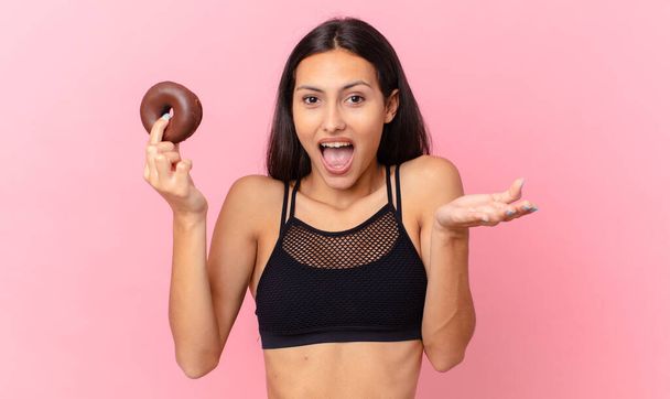 pretty fitness woman with a donut and a breakfast bowl - Foto, afbeelding